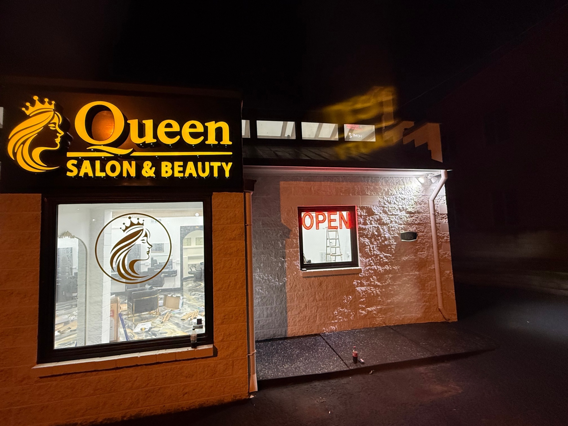 Queen Salon & Beauty illuminated storefront at night